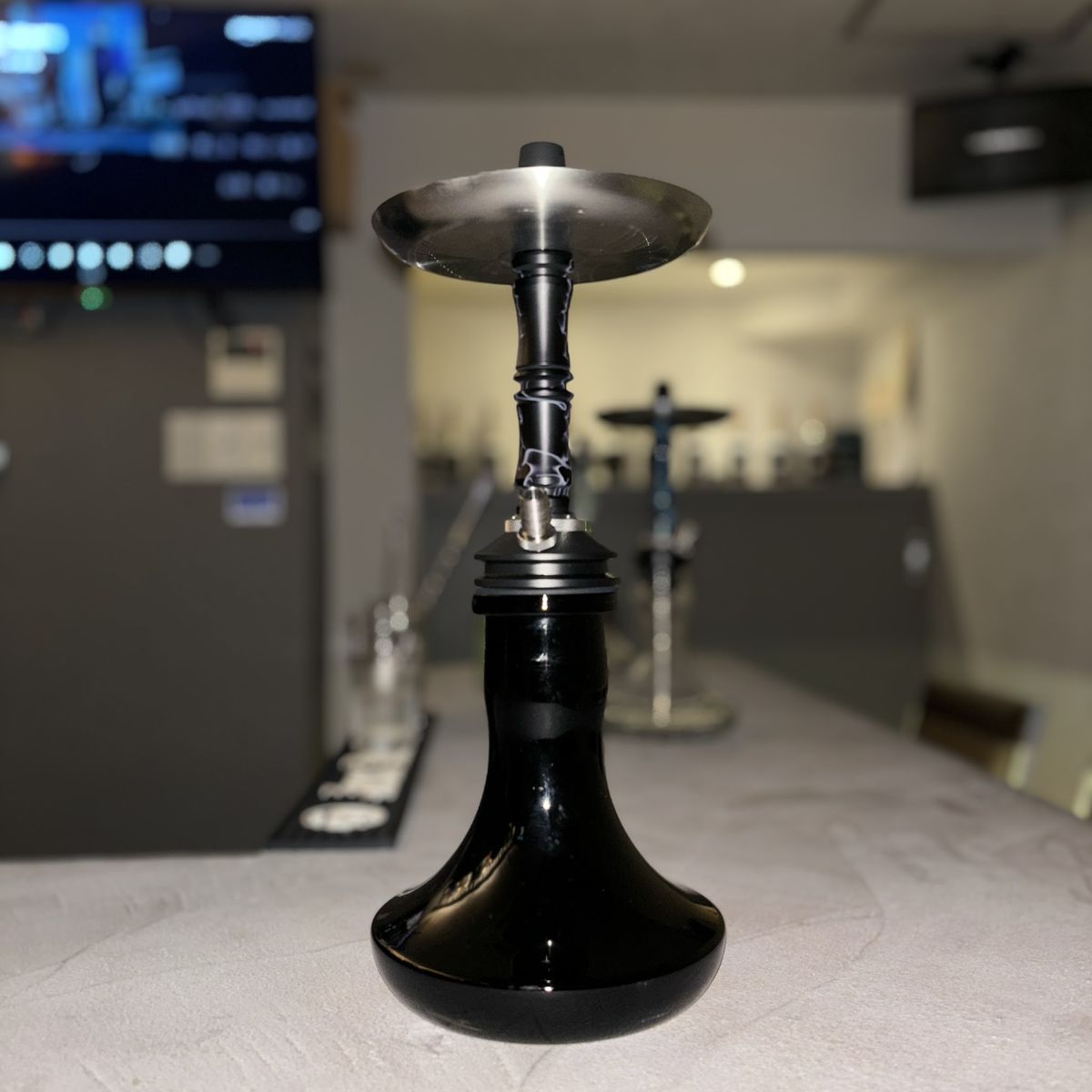 カウンターに置かれた黒いシーシャ。奥にもう一台が並ぶ